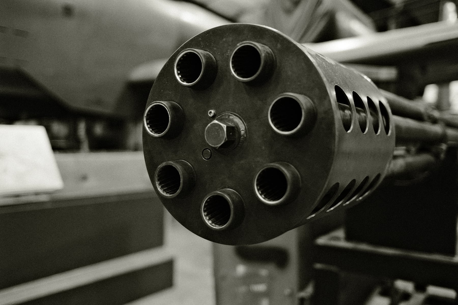Gatling gun barrels head-on in black and white, six parallel tubes in circular arrangement